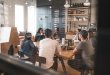 A diverse team of colleagues talking together around a table in a modern office